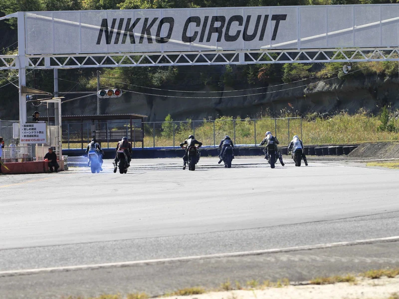 日光サーキットのゲート下を走るライダーたち
